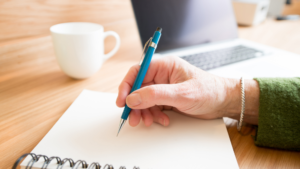 adult woman writing healthcare content on a piece of paper