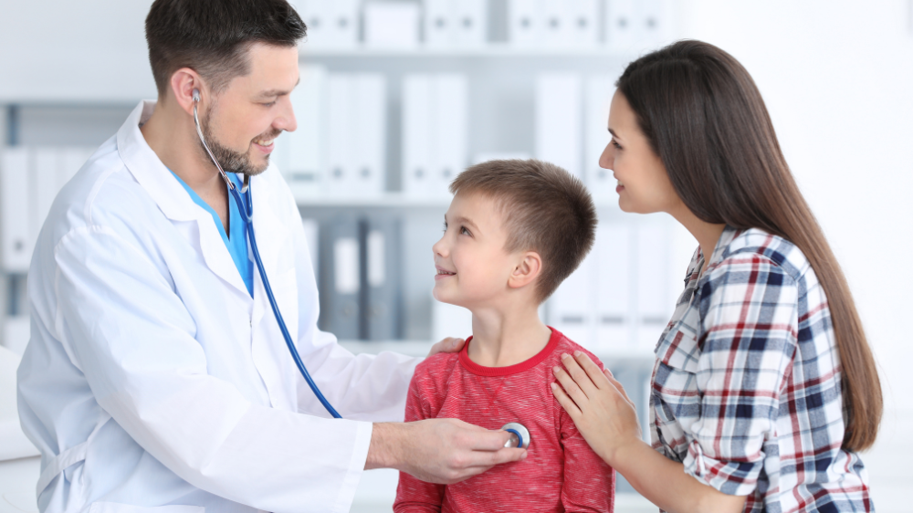 Children's doctor examining a little boy in hospital